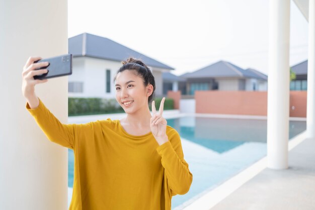 Mulher asiática tirando uma selfie com piscina