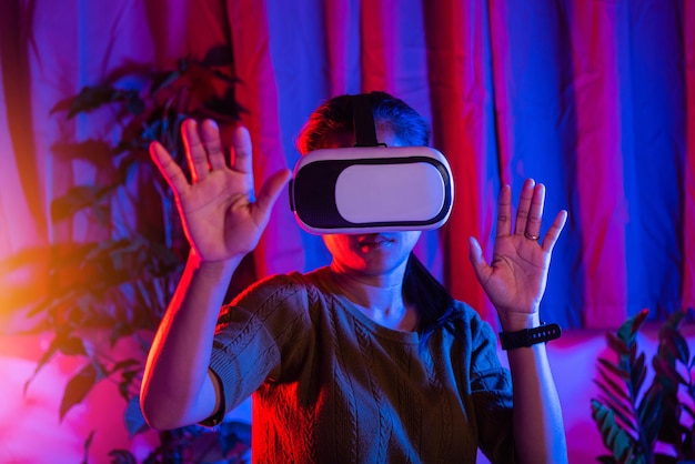 Mulher asiática tocando ar durante a experiência de vr em casa