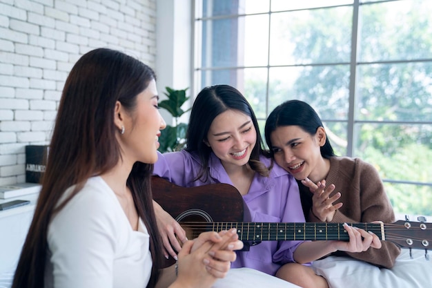 mulher asiática tocando violão no quarto