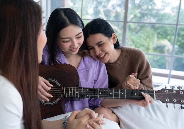 mulher asiática tocando violão no quarto