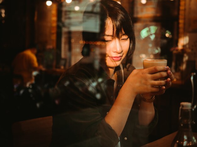 Foto mulher asiática tomando café no café café