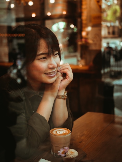 Foto mulher asiática tomando café no café café