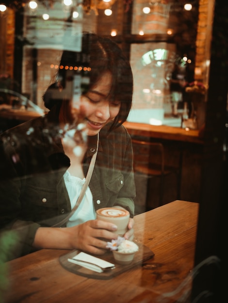 Mulher asiática tomando café no café café