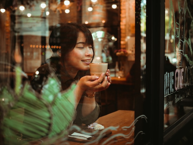 Mulher asiática tomando café no café café