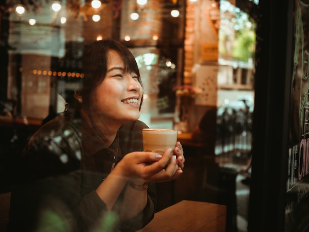 Foto mulher asiática tomando café no café café