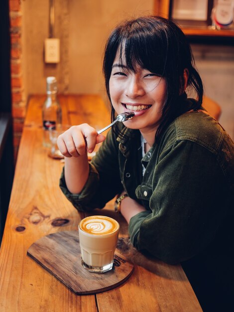 Mulher asiática tomando café no café café