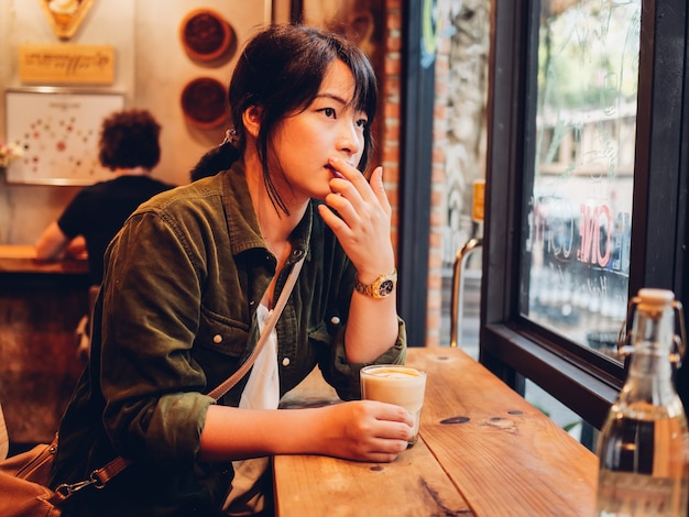 Foto mulher asiática tomando café no café café