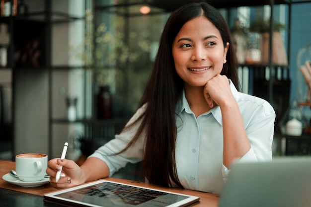 Mulher asiática, trabalhando com o computador portátil no café café