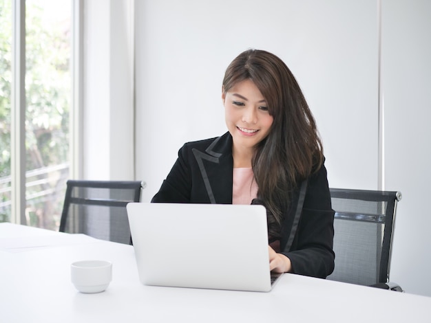 Foto mulher asiática trabalhando no escritório com café