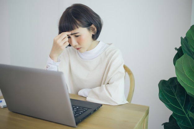 Mulher asiática trabalhar em casa. Ela é séria e estressada.