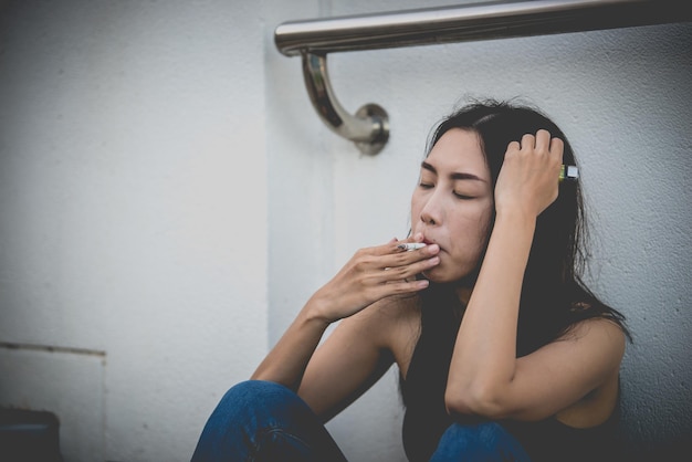 Mulher asiática triste por amorEla fuma por causa do estresse do namoradoConceito de mulher desgostoso