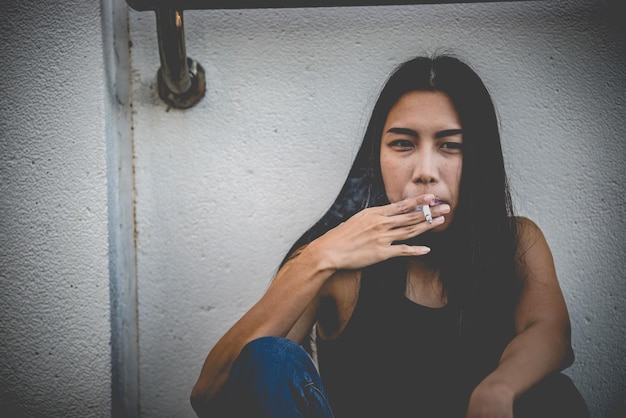 Mulher asiática triste por amorEla fuma por causa do estresse do namoradoConceito de mulher desgostoso