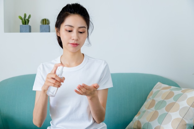 Foto mulher asiática usando álcool gel desinfetante para as mãos