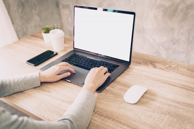 Mulher asiática usando computador portátil para trabalhar na mesa de madeira