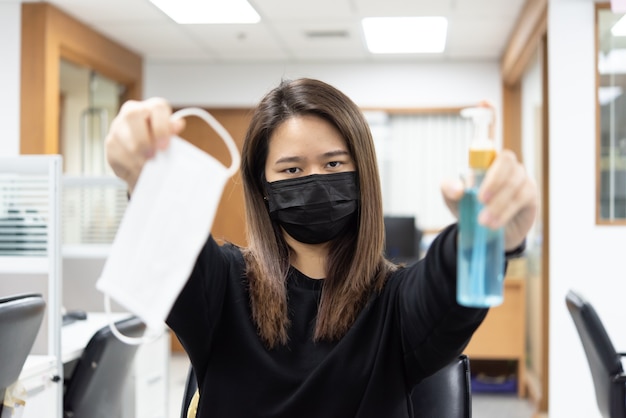 Foto mulher asiática usando máscara e máscara de proteção respiratória com gel antibacteriano de álcool para as mãos contra a gripe epidêmica covid19 ou vírus corona com emoção de medo em doença conceitual, surto, saúde na vida