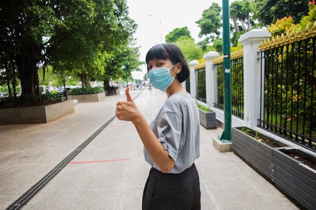 Mulher asiática usando máscara médica viajando em lugares públicos