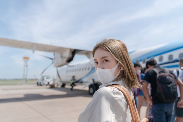 Mulher asiática usando máscara protetora no avião