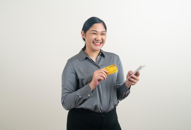 Mulher asiática usando smartphone com a mão segurando o cartão de crédito