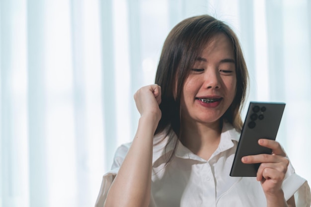 Mulher asiática usando smartphone na sala de estar em casa conceito de estilo de vida