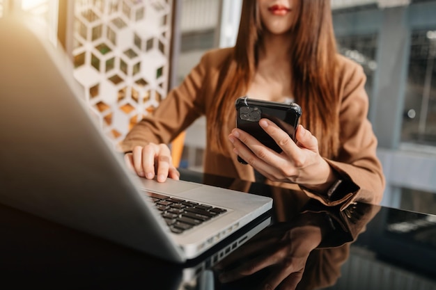 Mulher asiática usando telefone inteligente para pagamentos móveis, compras on-line, canais on-line sentados na tela de interface gráfica de ícones virtuais de mesa