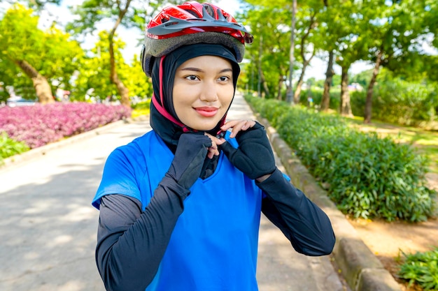 Mulher asiática usando um capacete se preparando para o passeio de bicicleta