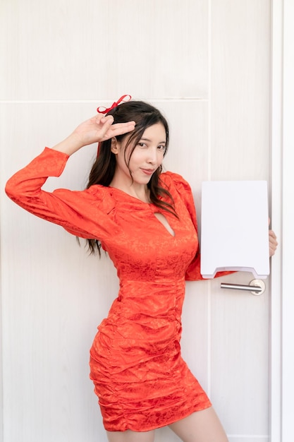 Mulher asiática usando vestido cheongsam qipao tradicional segurando o espaço da cópia da bandeira branca Feliz ano novo chinês