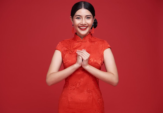 Mulher asiática usando vestido tradicional cheongsam qipao com gesto de parabéns