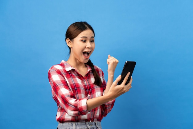 Mulher asiática vestindo camisa vermelha guingão com penteado de trança e olhando no smartphone com sentimento