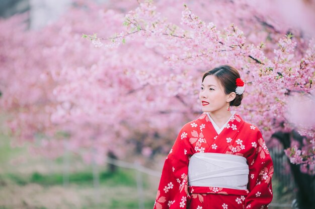 Mulher asiática vestindo quimono com flores de cerejeira