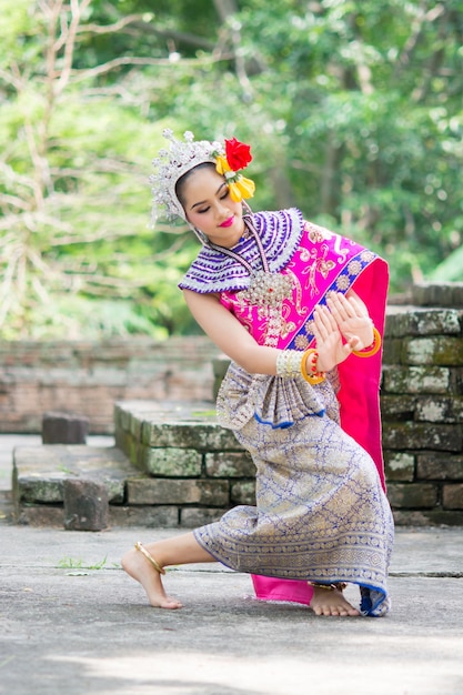 Mulher asiática vestindo traje nacional tradicional tailandês típico e dançando