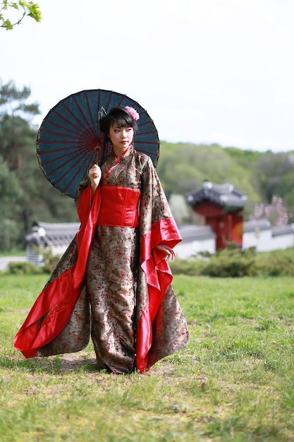 Mulher asiática vestindo um quimono tradicional japonês e caminhando no parque