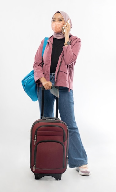 Foto mulher asiática viajando com mala e segurando seu celular