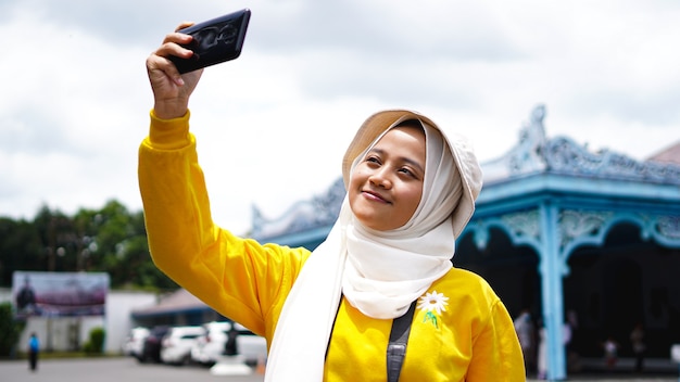 Mulher asiática viajando e tirando selfies no keraton solo