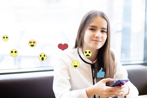 Mulher assiste às redes sociais, enviando emojis