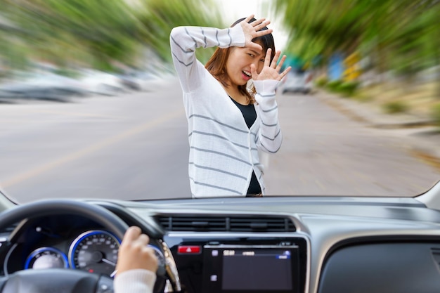 Foto mulher assustada na frente do carro vista através do pára-brisas