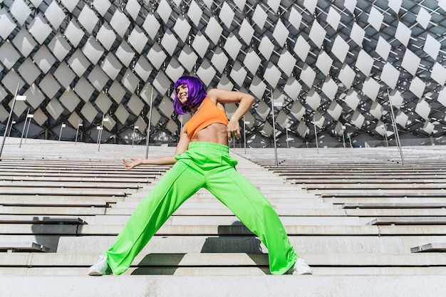 Mulher ativa vestindo roupas esportivas coloridas se apresentando na rua durante o dia de verão