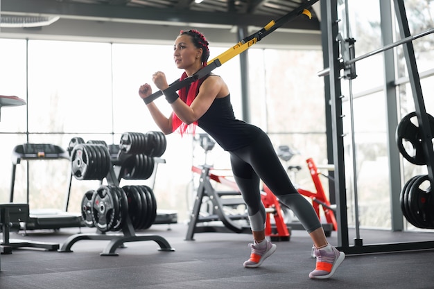 Mulher atleta treinando exercícios com sistema de suspensão