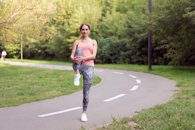 Mulher atlética aquecendo as pernas antes de exercícios de corrida