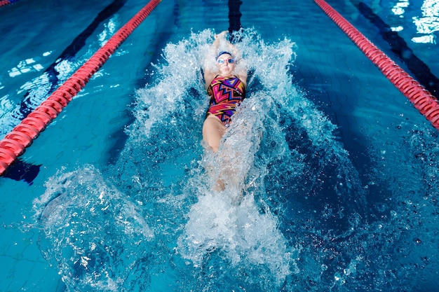 Mulher atlética nadando nas costas na piscina
