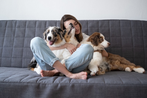 Mulher atraente abraçando cachorro pastor australiano de três cores merle