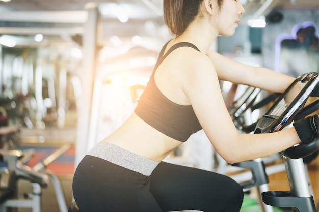 Mulher atraente, andar de bicicleta na Academia.