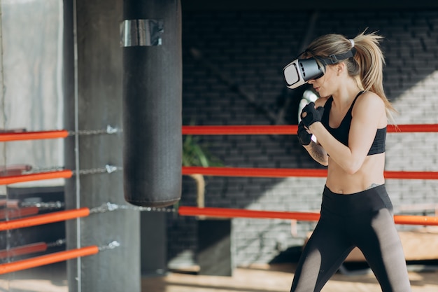 Mulher atraente boxe no treinamento de fone de ouvido vr 360 para chutar em realidade virtual