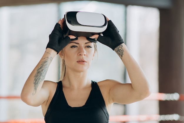 Mulher atraente boxe no treinamento de fone de ouvido VR 360 para chutar em realidade virtual