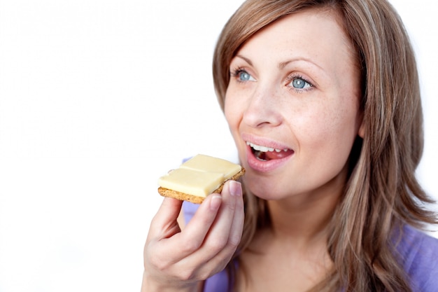 Mulher atraente comendo um biscoito com queijo