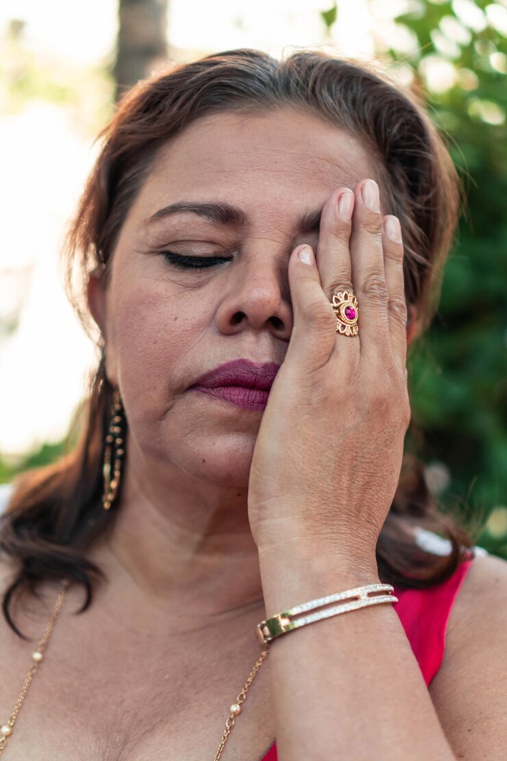 Foto mulher atraente de cinquenta anos com cabelo ruivo cobrindo o rosto com a mão