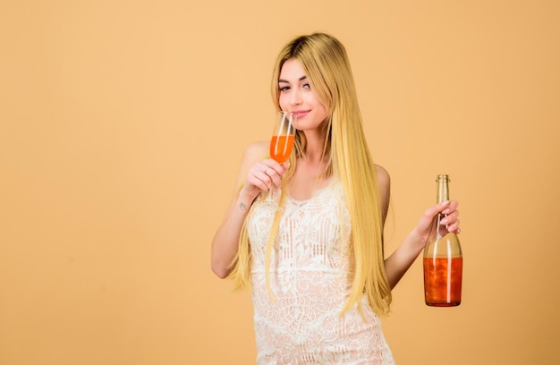 Mulher atraente desfrutar de licor de laranja de pêssego. Conceito de aperitivo. Álcool de luxo. Restaurante bar. Clube e festa para adultos com bebidas alcoólicas. Menina bebendo champanhe de brilho pérola. Mulher segura bebida de álcool de vidro.