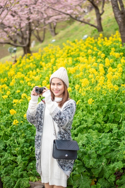 Mulher atraente é desfrutar com flor de cerejeira no parque