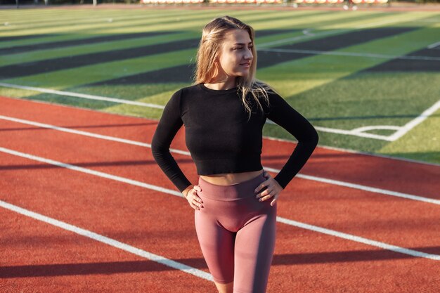 Mulher atraente e desportiva posando no estádio. Conceito de estilo de vida saudável