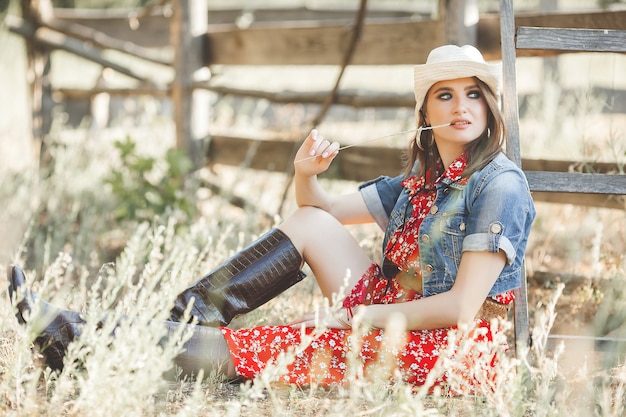 Foto mulher atraente em um vestido vermelho no campo