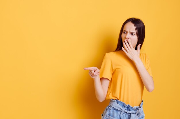 Mulher atraente em uma camiseta amarela emoções estilo verão fundo amarelo